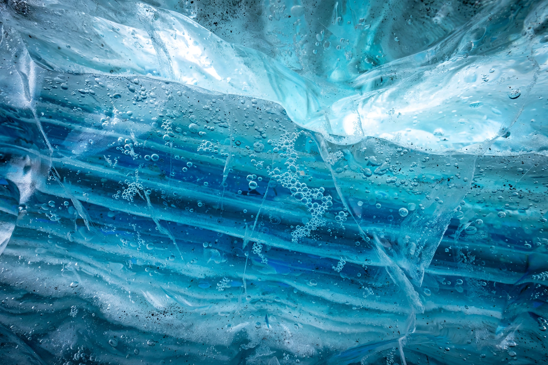 Extreme close-up of ancient compressed blue glacier ice with trapped air bubbles glowing inside an Iceland ice cave