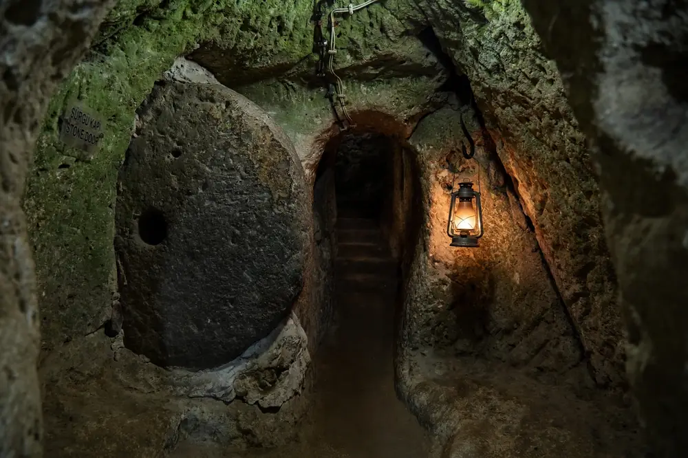 Massive ancient circular rolling stone door sealing a corridor inside Derinkuyu underground city, Cappadocia