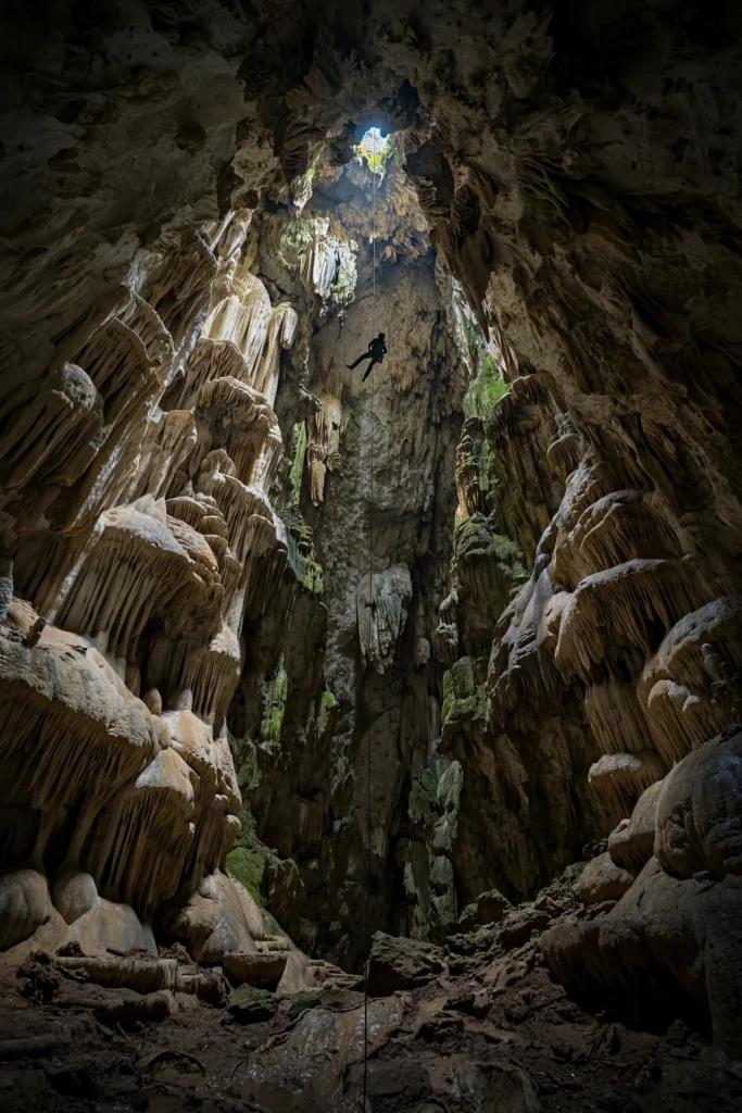 Explorers descending a deep vertical shaft in Sistema Cheve cave