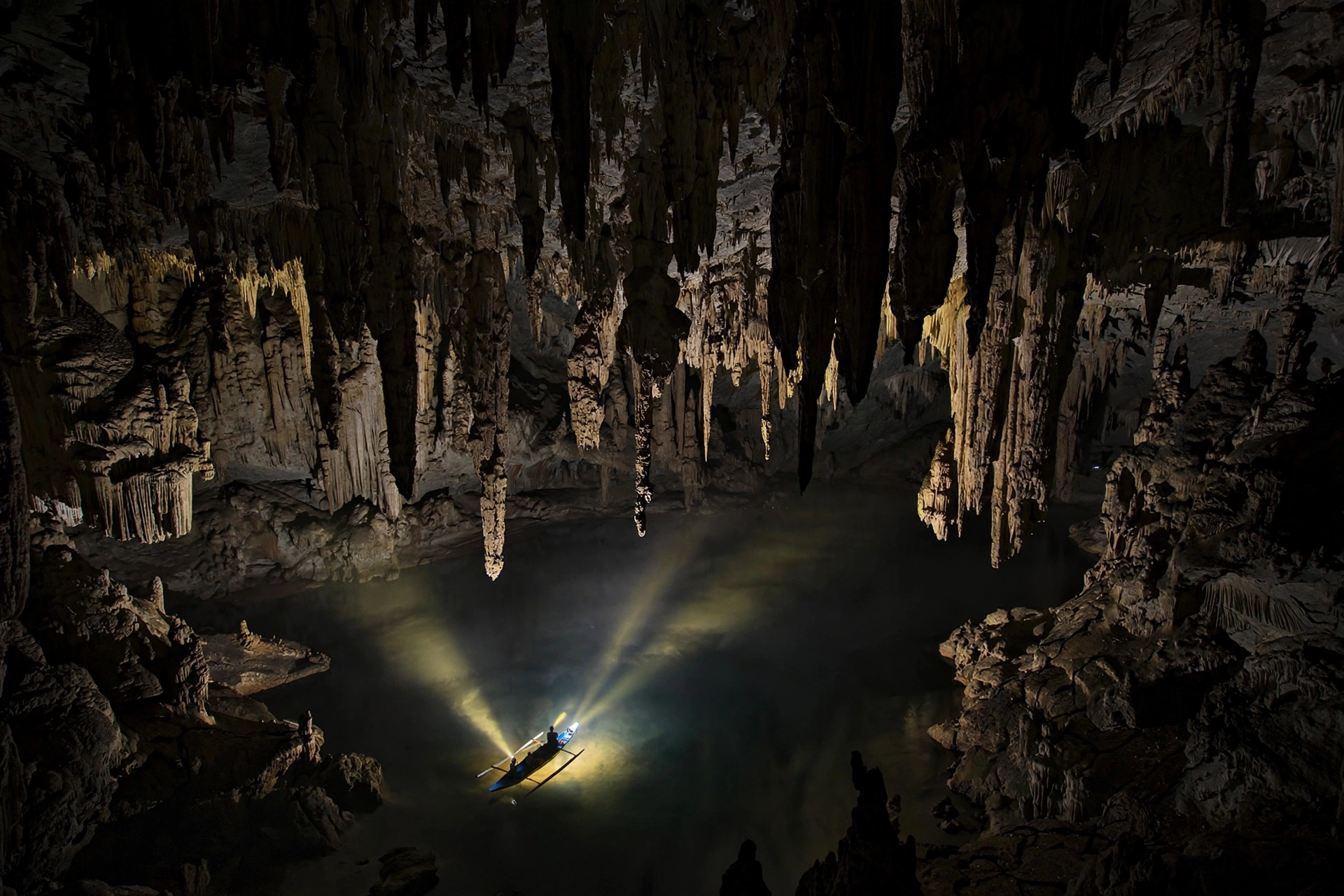 The Cathedral chamber inside the Puerto Princesa Underground River, a vast limestone hall with stalactites and a tiny paddle boat below