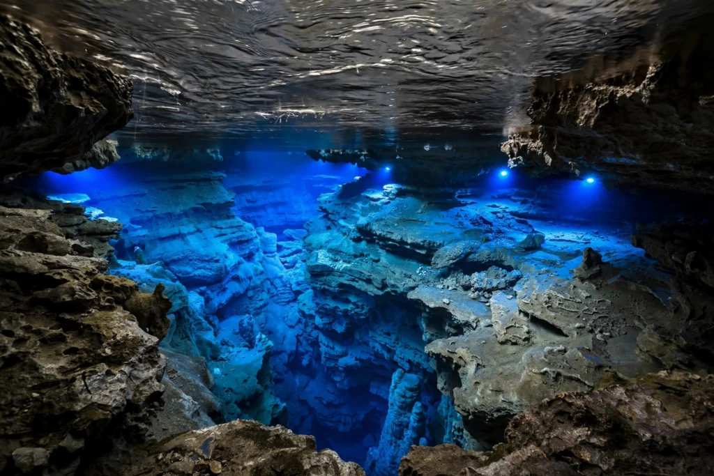 Close-up of the Dragon Blue underground lake showing the cobalt-blue water and submerged rock